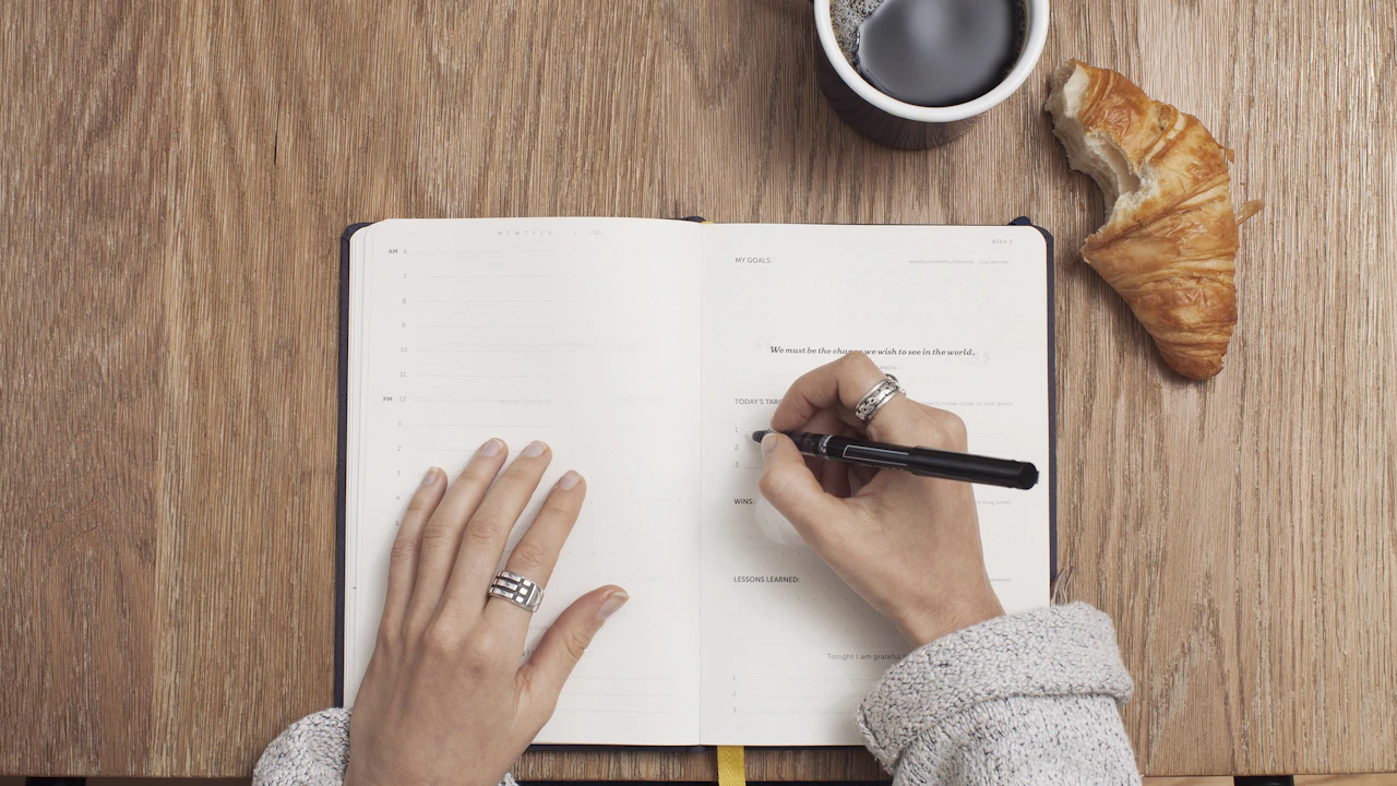 Une personne prend des notes dans un carnet.
