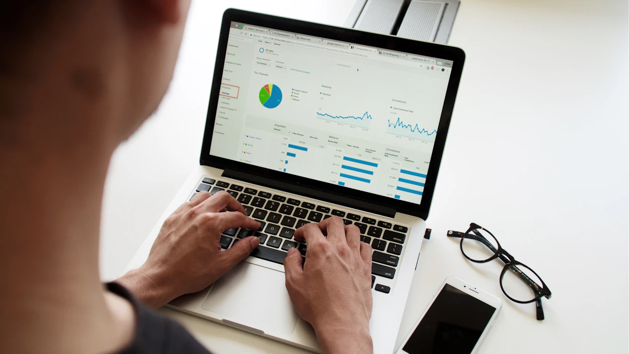 Un ordinateur portable affiche des graphiques, à côté de documents de travail.
