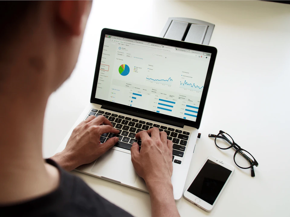 Un ordinateur portable affiche des graphiques, à côté de documents de travail.
